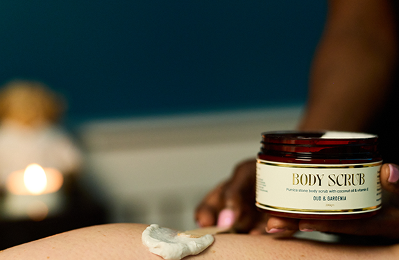 Person lying down have body scrub applied to their leg