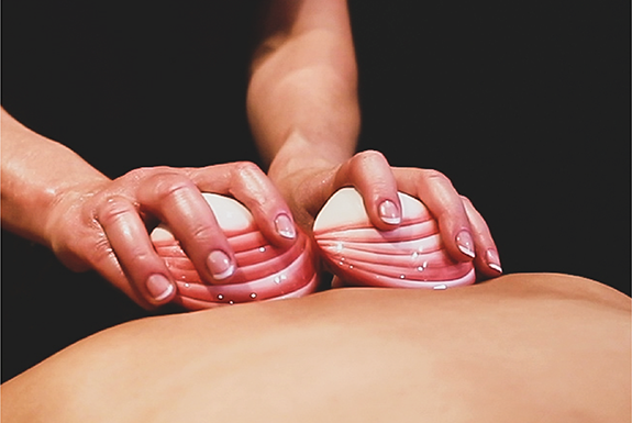 Lava shells being used on a person's back